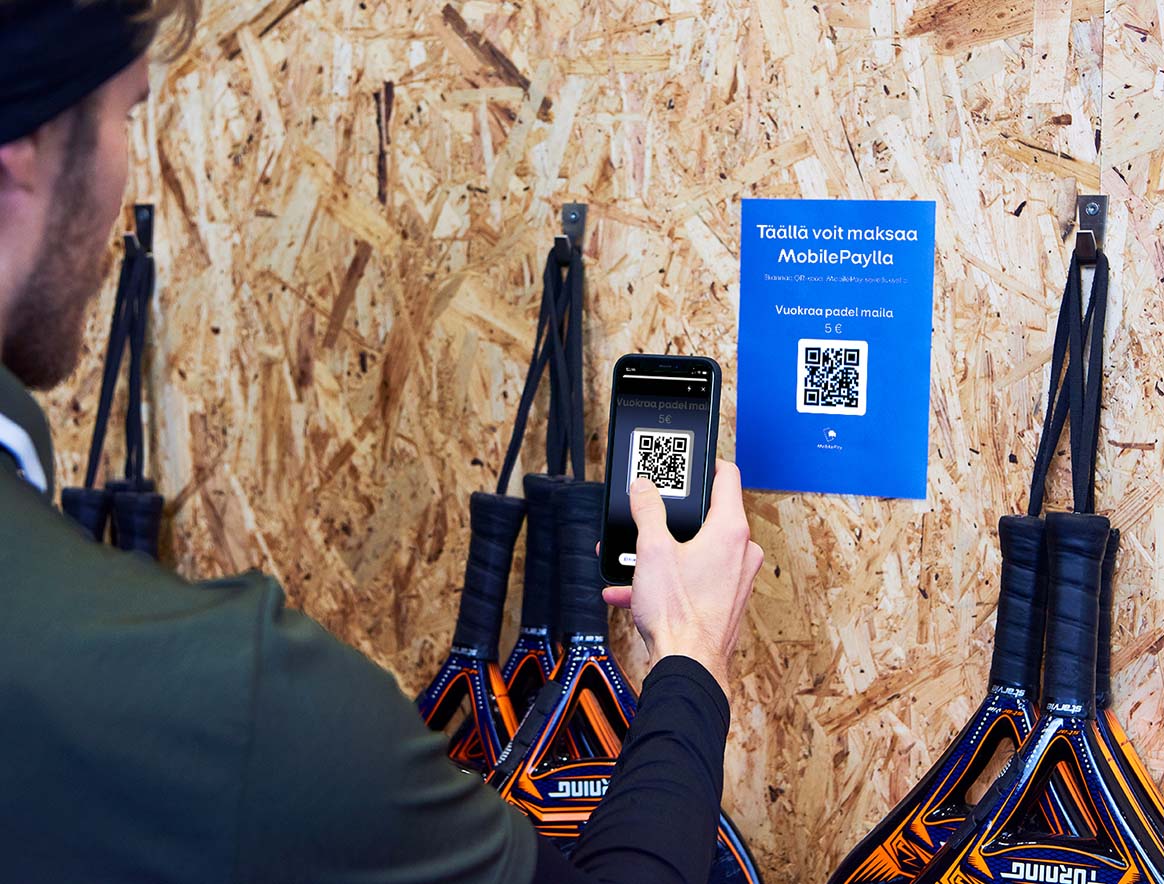 Asiakas skannaamassa QR-koodia MobilePaylla vuokratakseen padel mailan.
