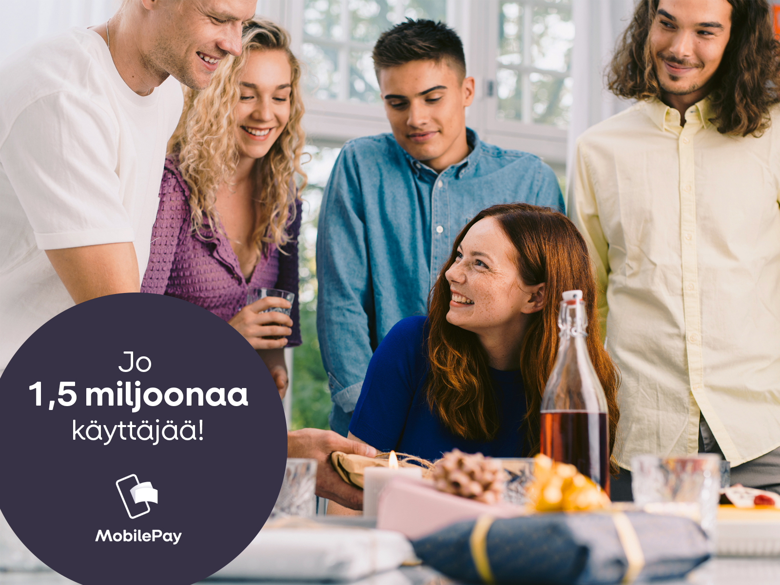Henkilöitä pöydän ympärillä juhlimassa puolitoista miljoonaa MobilePay käyttäjää