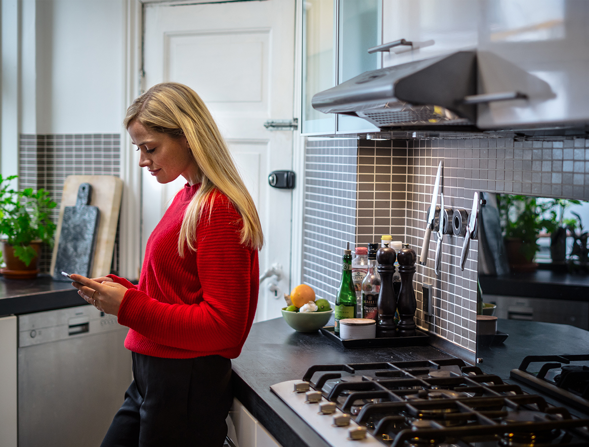 Nainen keittiössä käyttämässä MobilePayta.